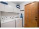 Laundry room with washer, dryer, storage cabinets, and access to the exterior at 9640 Moss Rose Cir, Highlands Ranch, CO 80129