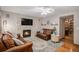 Cozy living room featuring a stone fireplace, hardwood floors, and comfortable leather seating at 9640 Moss Rose Cir, Highlands Ranch, CO 80129