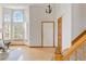 Bright foyer featuring hardwood floors, large arched window, staircase, and natural light at 9546 High Cliffe St, Highlands Ranch, CO 80129