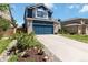 Attractive two-story blue house with brick accents, a driveway and landscaped garden at 9546 High Cliffe St, Highlands Ranch, CO 80129