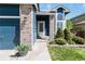 Charming front porch of a blue home with brick accents, lush landscaping, and a welcoming entrance at 9546 High Cliffe St, Highlands Ranch, CO 80129
