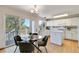 Eat-in kitchen boasts white cabinets, modern appliances, and access to an outdoor deck at 9546 High Cliffe St, Highlands Ranch, CO 80129