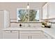 Bright kitchen with large window, white cabinets, stylish backsplash, and modern fixtures at 9546 High Cliffe St, Highlands Ranch, CO 80129
