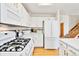 Well-equipped kitchen with stainless steel appliances, white cabinetry, and hardwood floors at 9546 High Cliffe St, Highlands Ranch, CO 80129