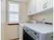Well-lit laundry room featuring updated washer and dryer, and shuttered window at 9546 High Cliffe St, Highlands Ranch, CO 80129