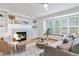 Warm living room featuring a fireplace, built-in shelves, hardwood floors, and plush seating at 9546 High Cliffe St, Highlands Ranch, CO 80129