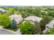 An aerial view of a brown two-story home surrounded by lush greenery and neighboring houses in a residential neighborhood at 3126 Aspen Creek Dr, Highlands Ranch, CO 80129