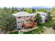 Two-story home with a double deck overlooking a landscaped yard with mature trees and a patio with a hot tub at 3126 Aspen Creek Dr, Highlands Ranch, CO 80129