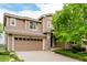 A well-maintained, two-story home featuring a two-car garage, stone accents, and a covered entryway at 3126 Aspen Creek Dr, Highlands Ranch, CO 80129