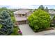 Charming two-story home with a well-manicured lawn, mature trees, and a spacious driveway leading to an attached two-car garage at 3126 Aspen Creek Dr, Highlands Ranch, CO 80129
