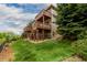 Two-story home exterior with multi-level decks, a lawn, and lush landscaping at 3126 Aspen Creek Dr, Highlands Ranch, CO 80129