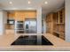 Close-up shot of the kitchen island cooktop and stainless steel appliances in a spacious kitchen at 3126 Aspen Creek Dr, Highlands Ranch, CO 80129