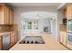 Kitchen with wooden cabinets and tile backsplash, open to the living room with a fireplace at 3126 Aspen Creek Dr, Highlands Ranch, CO 80129
