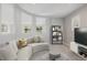 Modern living room featuring neutral walls, carpet, and a curved white sofa near unique windows at 3126 Aspen Creek Dr, Highlands Ranch, CO 80129