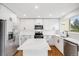 Modern kitchen with white cabinets, stainless steel appliances, a large island, and hardwood floors at 12678 W Dorado Pl, Littleton, CO 80127