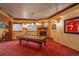 Finished basement with pool table, brick fireplace, and Elway jersey for sports fans at 11904 W Auburn Dr, Denver, CO 80228