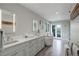 This bright and spacious bathroom features double sinks, a soaking tub, and french doors to the deck at 11904 W Auburn Dr, Denver, CO 80228