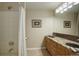 Bright bathroom featuring tile flooring, double vanity, and a shower with a curtain at 11904 W Auburn Dr, Denver, CO 80228
