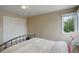 Bedroom featuring light-colored walls, carpet, a window, and a double door closet at 11904 W Auburn Dr, Denver, CO 80228
