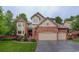 Charming two-story brick home with a well-manicured lawn and a spacious three-car garage at 11904 W Auburn Dr, Denver, CO 80228