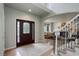 Inviting foyer featuring a decorative front door, hardwood floors, and an open staircase at 11904 W Auburn Dr, Denver, CO 80228