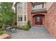 Elegant brick home showcasing a beautiful front entrance with a charming seating area at 11904 W Auburn Dr, Denver, CO 80228