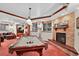 Bright and airy game room boasts a billiard table, fireplace, media area, and egress windows at 11904 W Auburn Dr, Denver, CO 80228