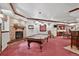 Spacious game room featuring a brick fireplace, a billiards table, and a bar area with seating at 11904 W Auburn Dr, Denver, CO 80228