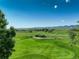 Picturesque golf course framed by mature trees and distant mountains on a clear day at 11904 W Auburn Dr, Denver, CO 80228