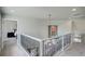 Upstairs hallway with decorative iron railing, neutral walls, and artwork, creating an inviting transition space at 11904 W Auburn Dr, Denver, CO 80228