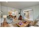 Open-concept living space with hardwood floors, elegant furnishings, and a view into the dining area at 11904 W Auburn Dr, Denver, CO 80228