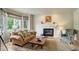 Cozy living room with a fireplace, comfortable seating, and natural light from large windows at 11904 W Auburn Dr, Denver, CO 80228
