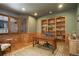 This office features hardwood floors, built-in bookshelves, wainscotting, and a large window with shutter shades at 11904 W Auburn Dr, Denver, CO 80228