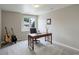 Bright office with gray carpet, wood desk, guitars, and natural light from the window at 11904 W Auburn Dr, Denver, CO 80228