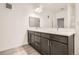 Bright bathroom featuring a double sink vanity with dark cabinets, modern lighting, and laminate flooring at 9185 Wilde Ln # 301, Parker, CO 80134