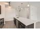 Bright kitchen features a large island with modern lighting, dark cabinets and stainless steel dishwasher at 9185 Wilde Ln # 301, Parker, CO 80134