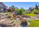 Landscaped backyard with fire pit, Adirondack chairs, garden beds, and lush greenery at 10687 Featherwalk Way, Highlands Ranch, CO 80126
