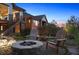 Charming backyard with stone fire pit and outdoor seating area, set among lush greenery at 10687 Featherwalk Way, Highlands Ranch, CO 80126