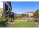 Multi-level backyard with outdoor seating, fire pit, garden beds and a lush green lawn at 10687 Featherwalk Way, Highlands Ranch, CO 80126