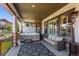 Relaxing covered patio with a hot tub, wicker sofa, and outdoor heater for year-round enjoyment at 10687 Featherwalk Way, Highlands Ranch, CO 80126