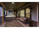 Relaxing covered patio with a hot tub, wicker sofa, and outdoor heater all lit up at twilight at 10687 Featherwalk Way, Highlands Ranch, CO 80126