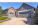 Charming home with stone and siding, complemented by a three-car garage and tidy landscaping at 10687 Featherwalk Way, Highlands Ranch, CO 80126
