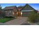 Home exterior showing stone details, three-car garage, and a well-kept lawn, perfect for curb appeal at 10687 Featherwalk Way, Highlands Ranch, CO 80126