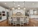 Kitchen island with granite countertop, pendant lighting, stainless steel appliances, and hardwood flooring at 10687 Featherwalk Way, Highlands Ranch, CO 80126
