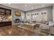 Bright and cozy living room features a fireplace, built-in shelving, and large windows with plantation shutters at 10687 Featherwalk Way, Highlands Ranch, CO 80126