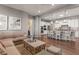 Open-concept living area with hardwood floors flows to the kitchen with a large island and breakfast bar at 10687 Featherwalk Way, Highlands Ranch, CO 80126