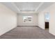 Large bedroom with tray ceiling, carpet, and bright window at 24325 E Ada Pl, Aurora, CO 80018