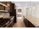 Granite countertops, dark wood cabinetry, and stainless appliances in this kitchen at 24325 E Ada Pl, Aurora, CO 80018