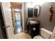Bathroom features tiled floor, vanity, toilet, and access to a hallway and other areas of the home at 12242 Bannock Cir # D, Denver, CO 80234
