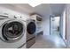 Basement laundry area with modern appliances, storage shelves and lighting at 12242 Bannock Cir # D, Denver, CO 80234